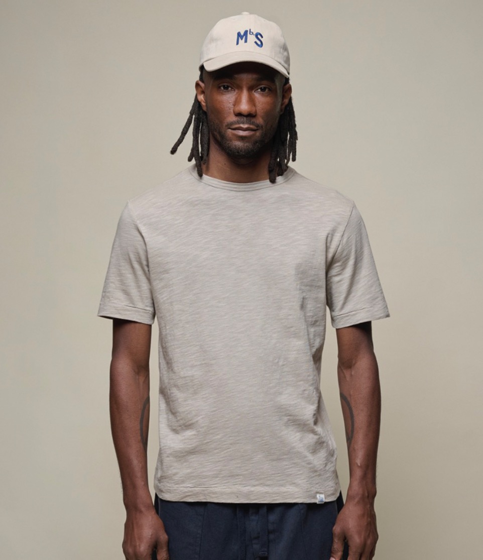 man wearing grey pima cotton t-shirt and cap in khaki