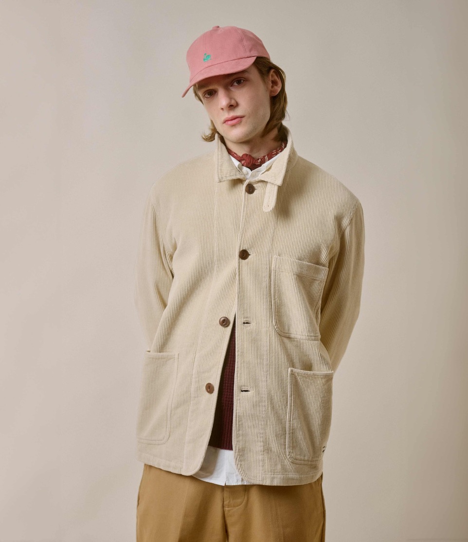 man wearing corduroy jacket and a logo cap