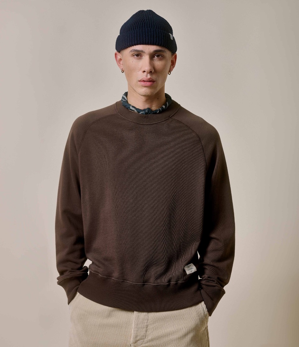 man wearing sweatshirt in brown along with a beanie and bandana