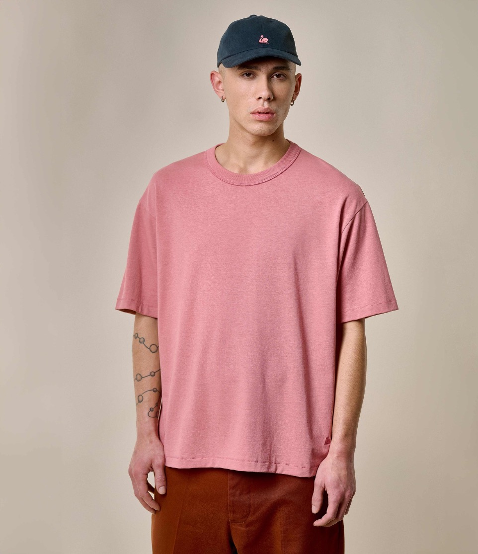 man wearing oversized t-shirt, chino and swan logo cap