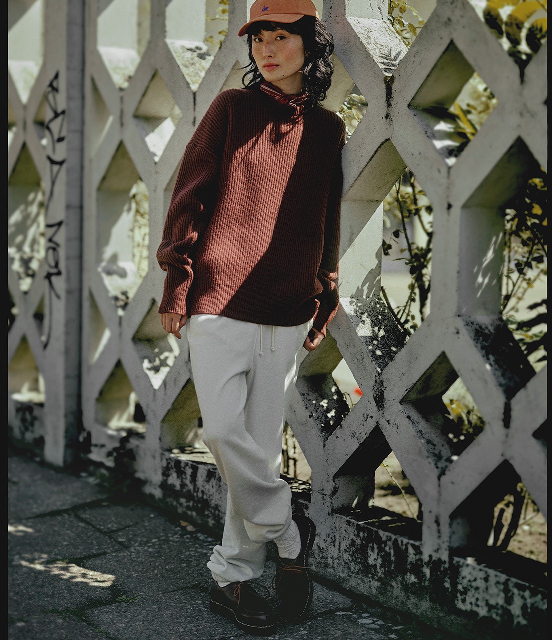 woman wearing sweatpants and knitted pullover and swan logo cap