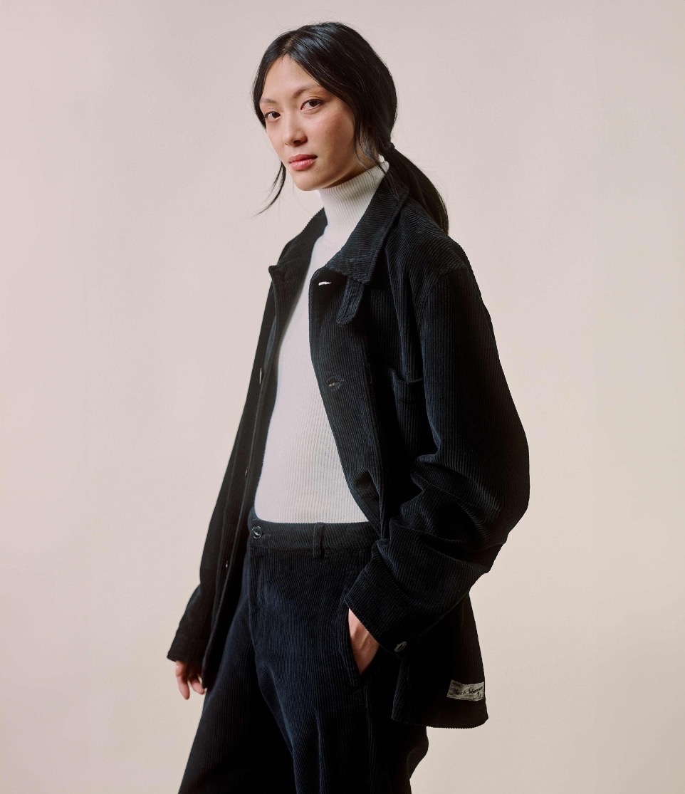 woman wearing black corduroy pants and jacket and a knitted turtleneck pullover