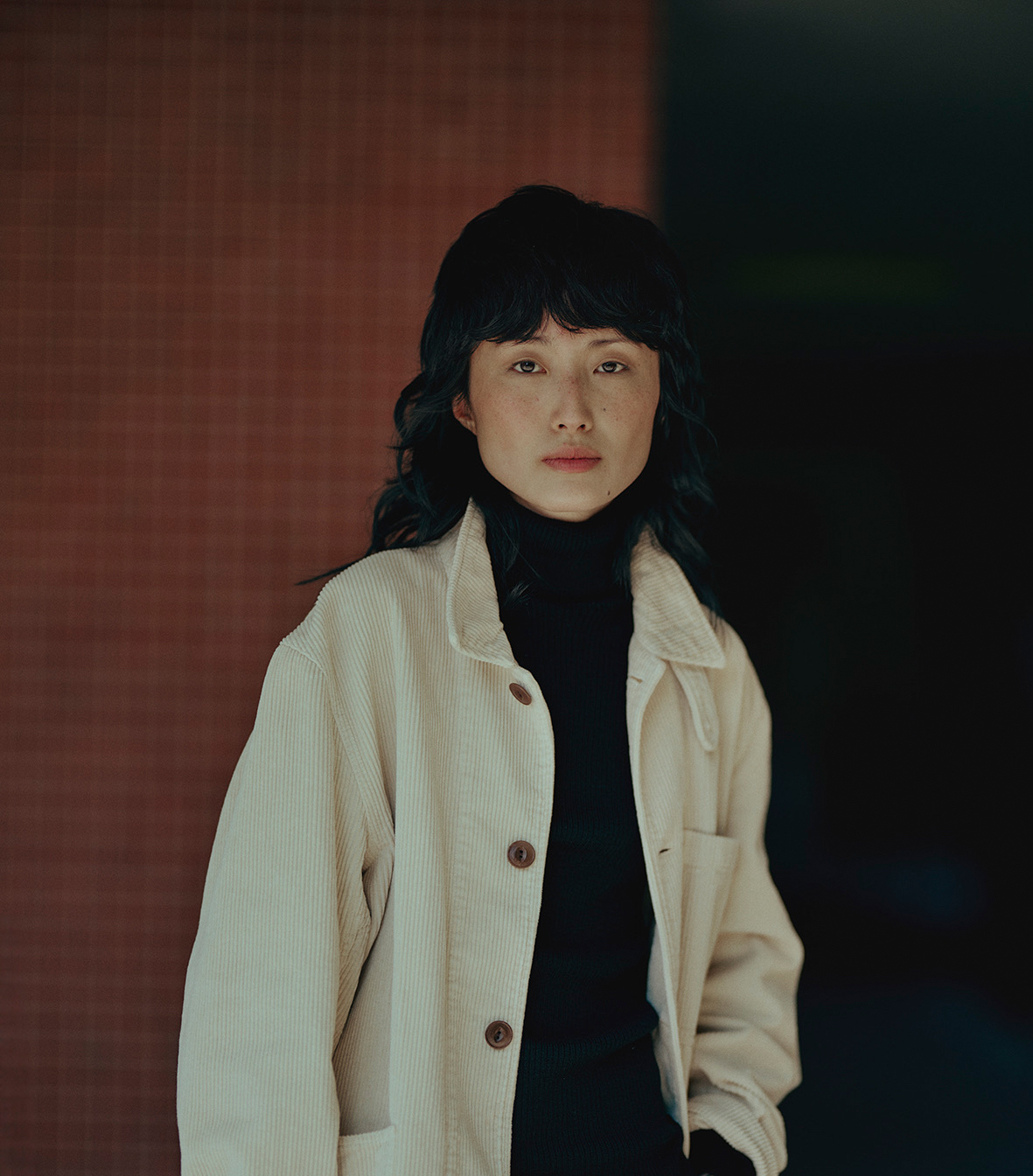 Woman wearing white corduroy jacket above black turtleneck pullover