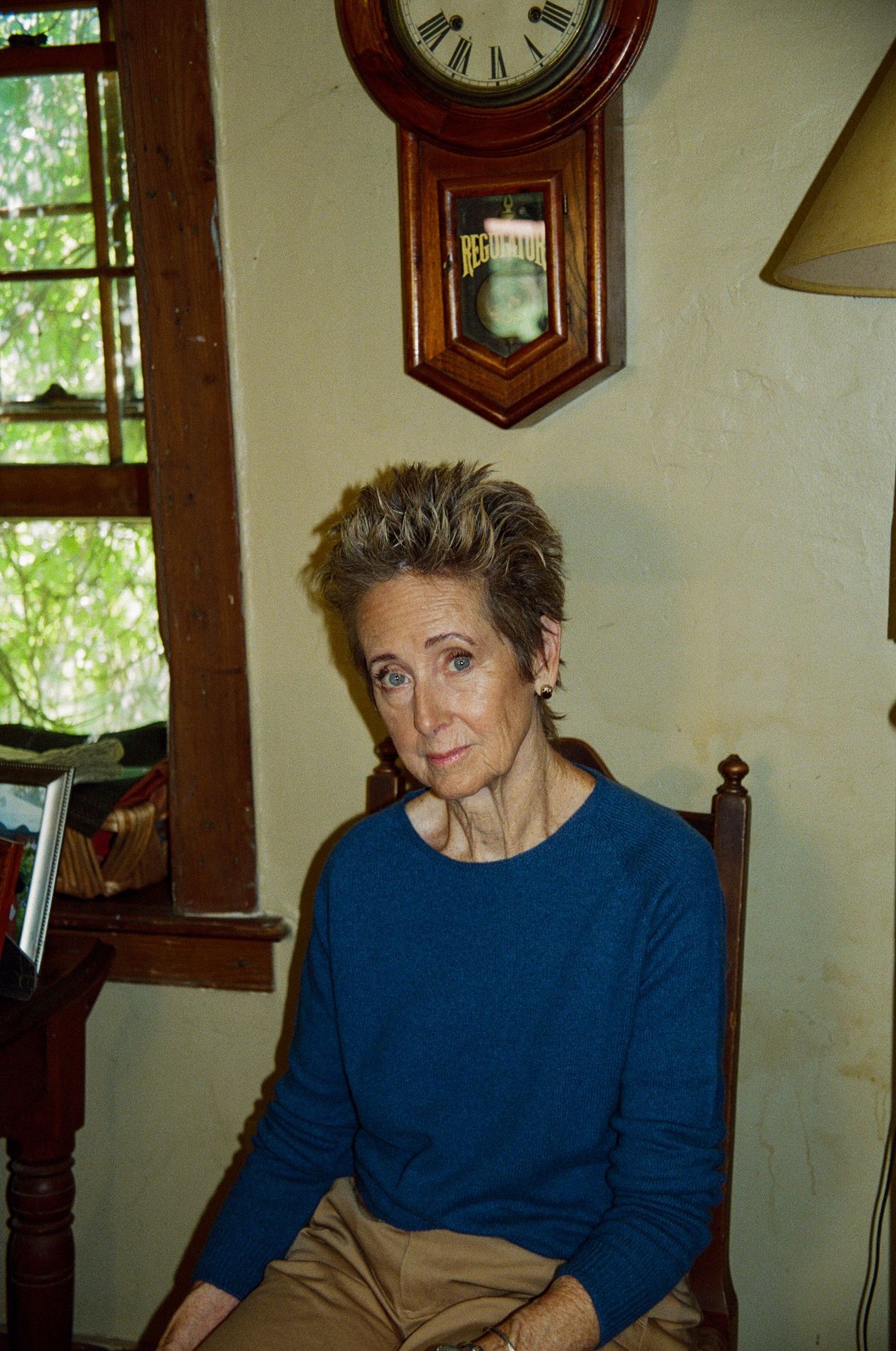 Woman on a chair wearing blue crewneck pullover