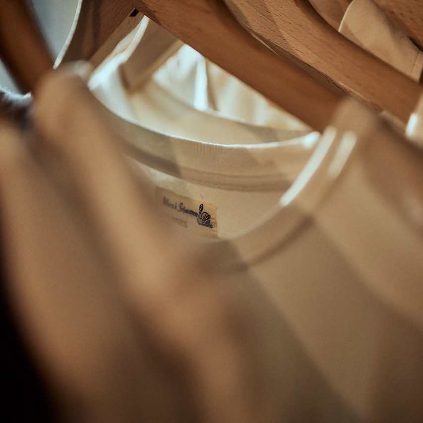 white T-shirts hanging on a rack