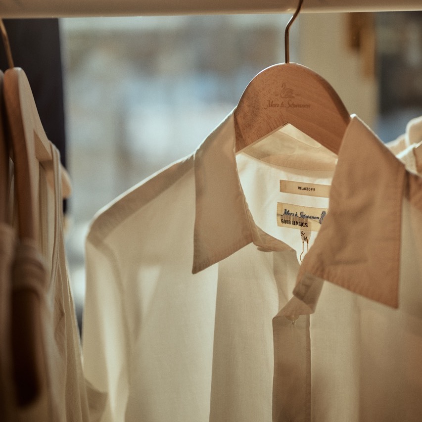 white organic cotton shirt hanging on a rack