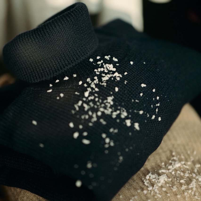 turtleneck pullover laying on a table with snow on it