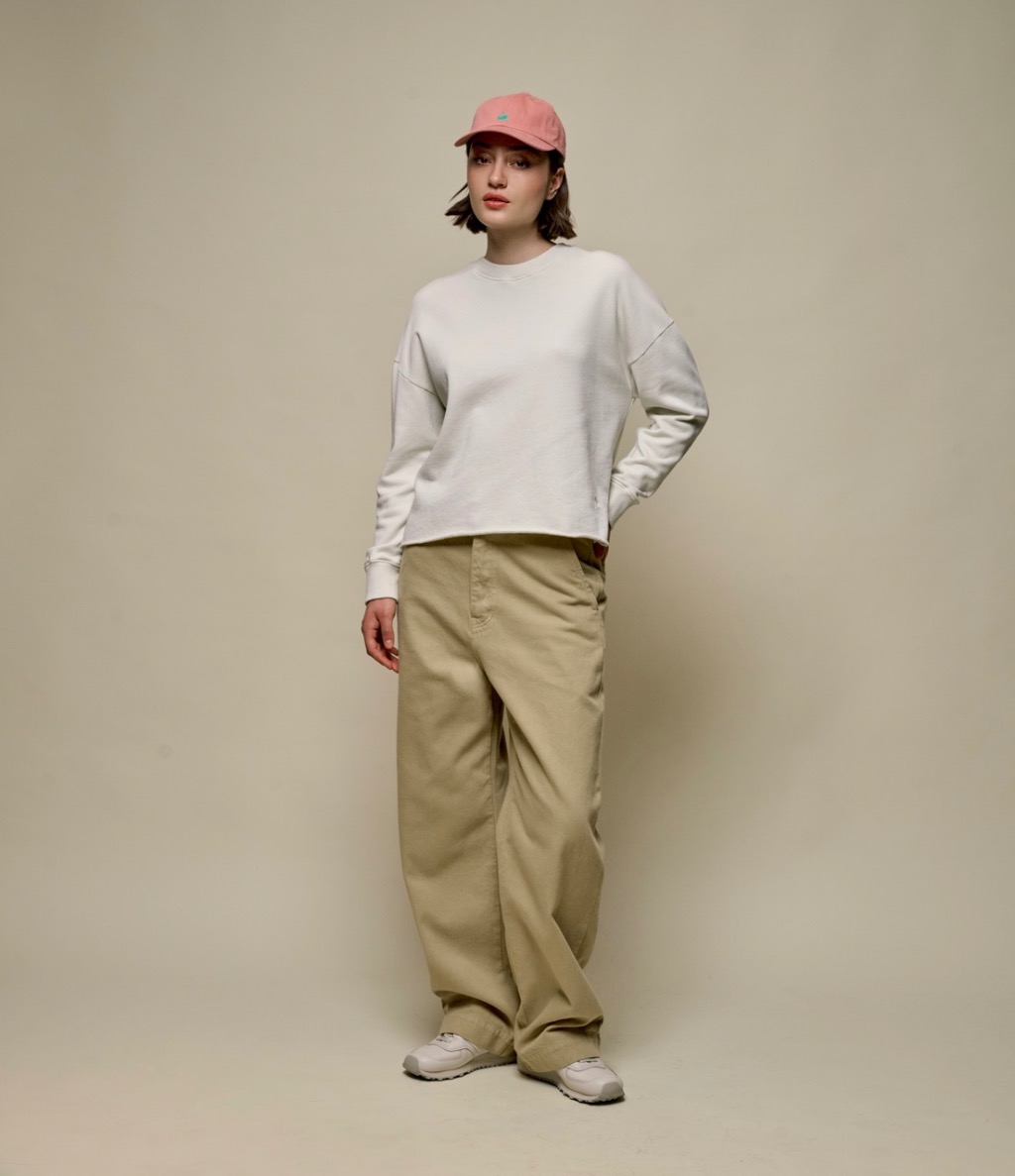 woman wearing a white sweatshirt and pants in khaki