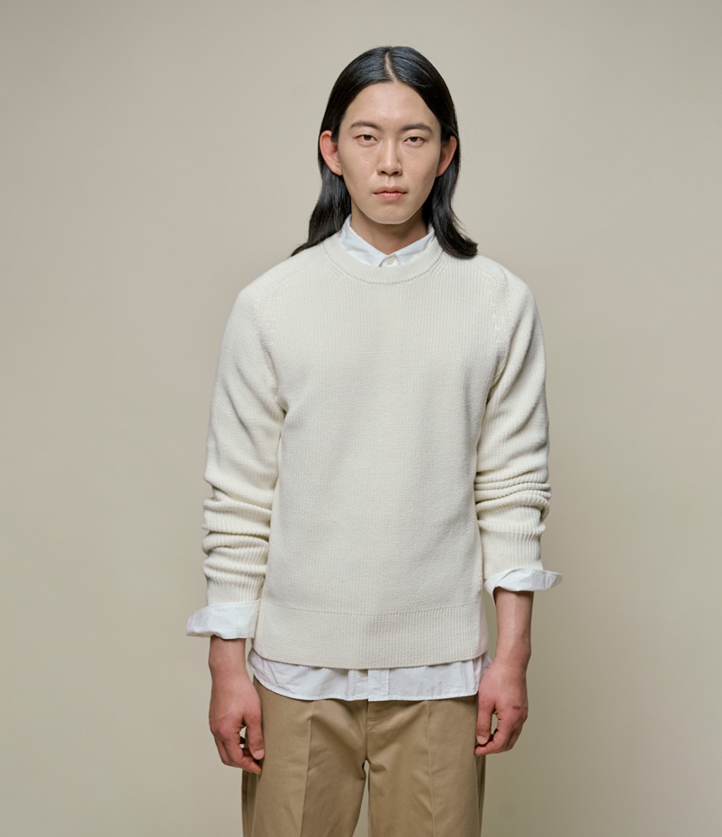 man wearing knitted pullover over a white shirt and chinos